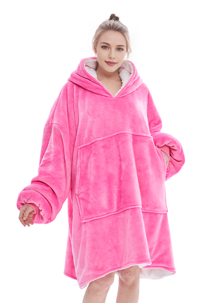 Hot pink SNUGLFIT™ Hoodie Blanket modeled, showcasing oversized design and plush materials.