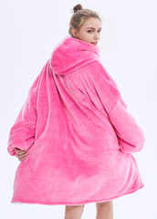 Hot pink SnuglFit™ hoodie blanket worn by a person, showcasing its oversized comfort and style.