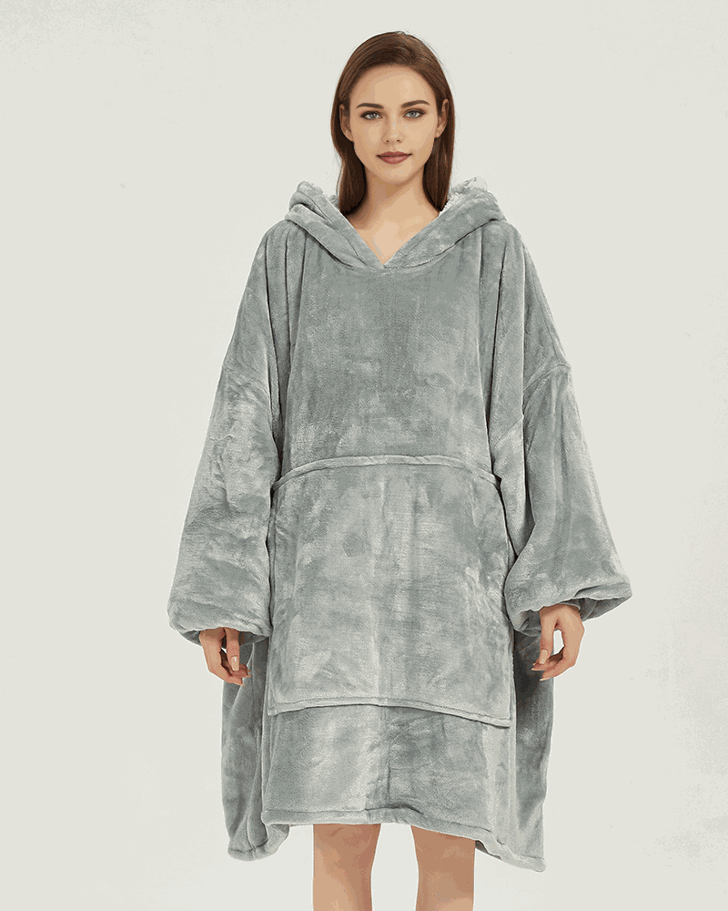 SNUGLFIT™ Hoodie Blanket in light grey, featuring oversized comfort, Sherpa fleece interior, and sustainable design. Perfect for home and outdoor coziness.